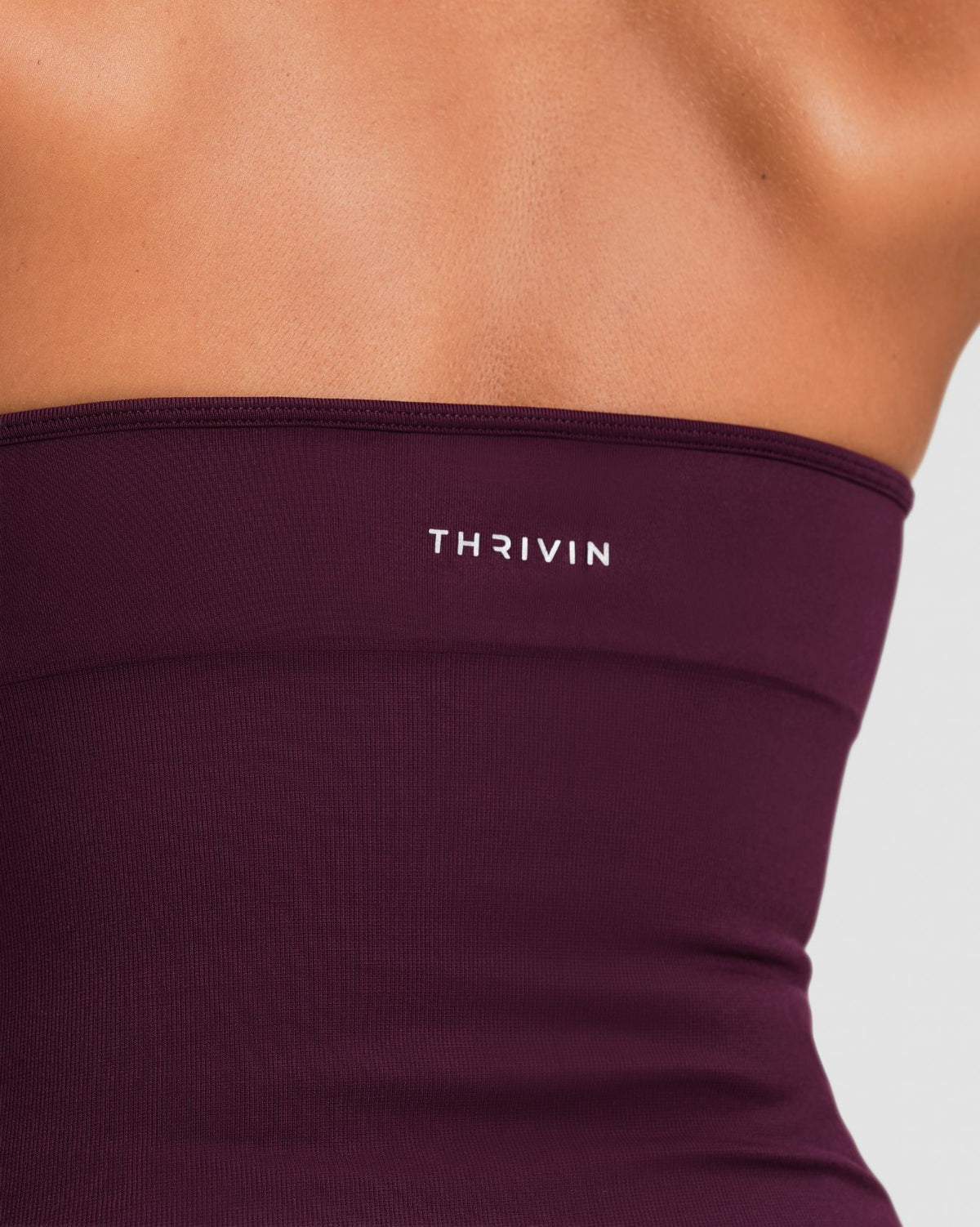 Elevate Sculpting Seamless Halterneck Top in Winter Plum Red, back close-up of Thrivin logo and smooth seamless knit