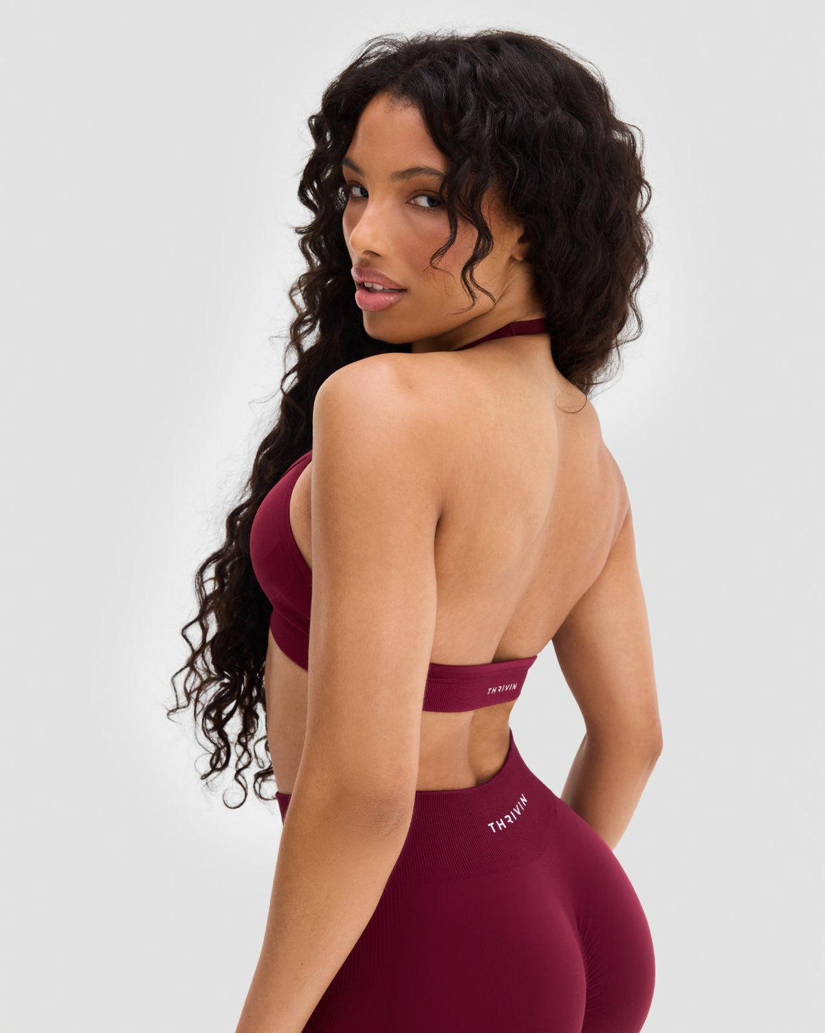 Elevate Sculpting Seamless Adjustable Halter Bra in Fine Wine Red, back three-quarter view with open back over shoulder