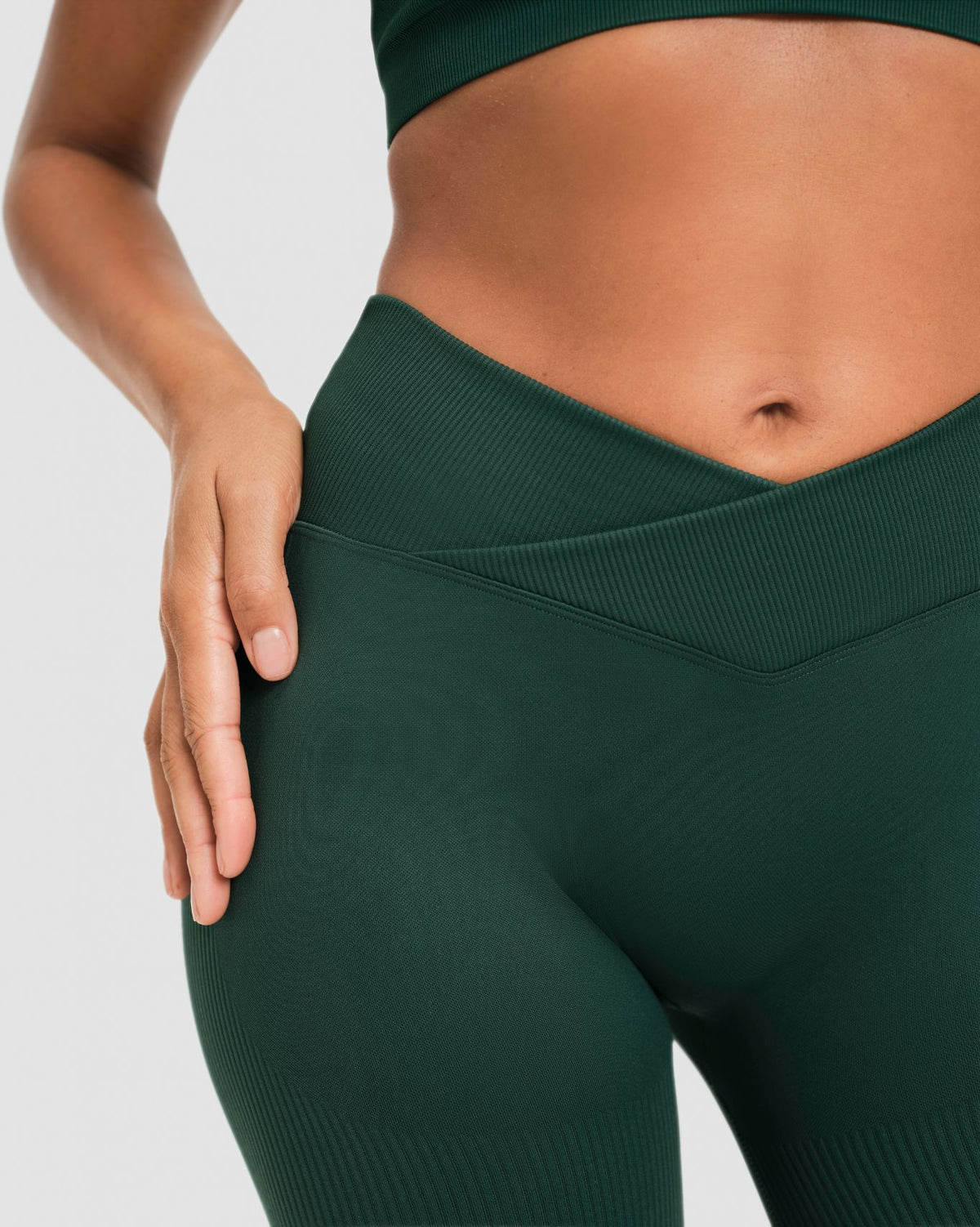 Elevate Sculpting Mid V-Waist Flare Leggings in Pine Green, front close-up of crossover V-waistband and ribbed knit