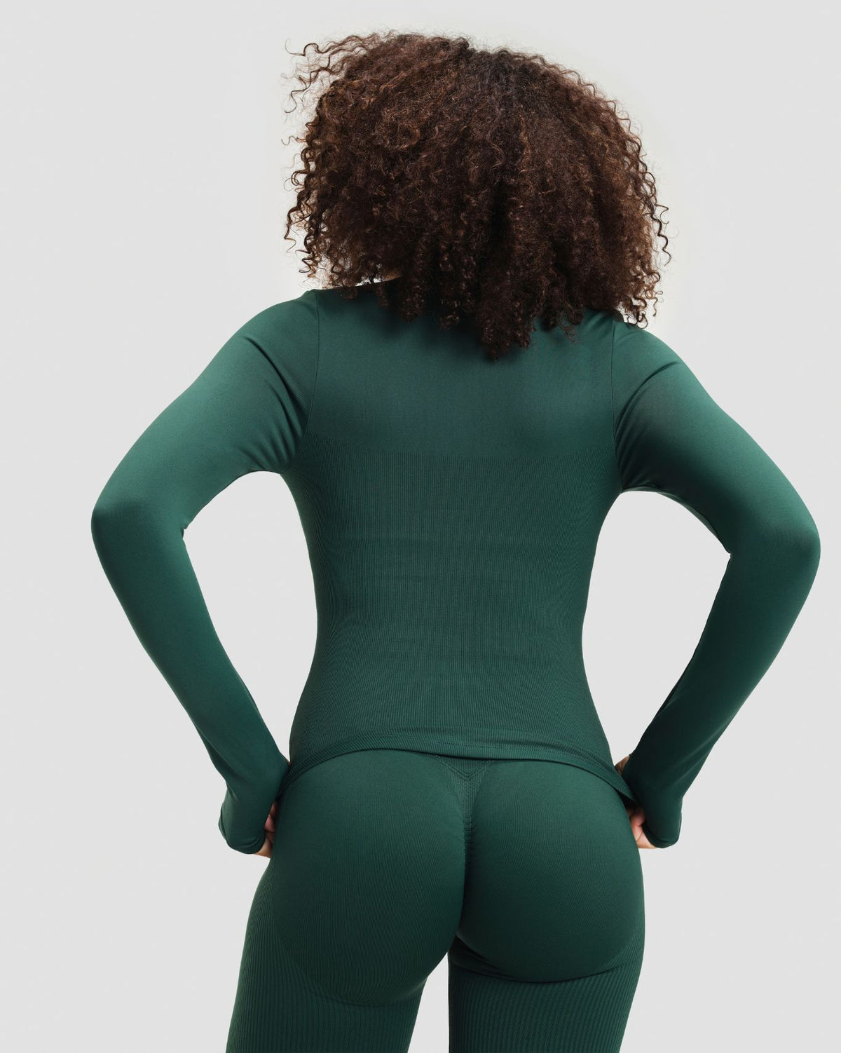 Elevate Compression Long Sleeve Jacket in Pine Green, back view of fitted long sleeves, thumbholes and curved hem
