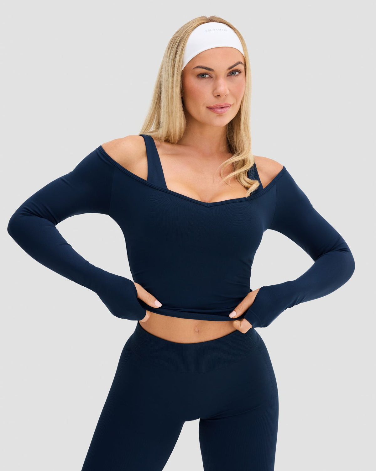 Elevate Sculpting Seamless V-Neck Top in Midnight Navy Blue, front view with hands on hips, cold shoulder neckline