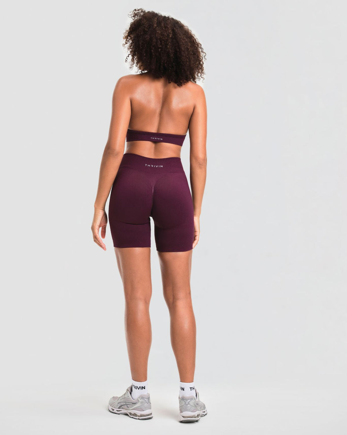 Elevate Sculpting Mid Waist Scrunch Shorts in Winter Plum Red, full-length back view with Thrivin logo waistband