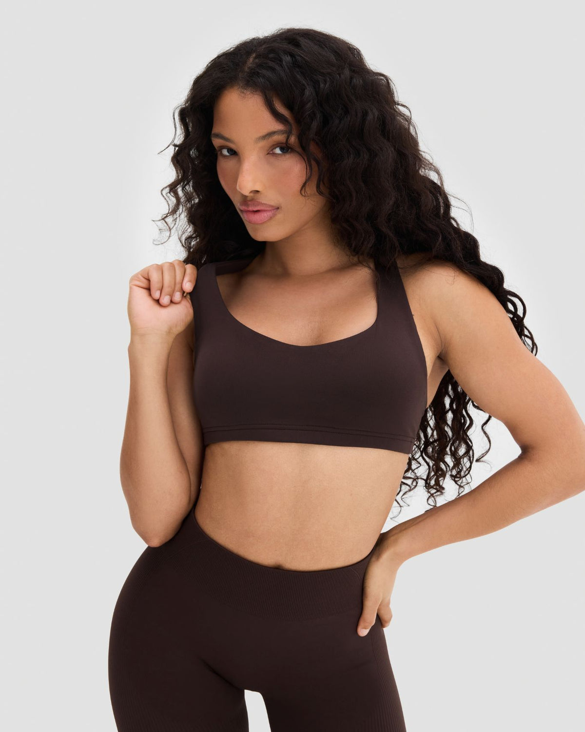 Elevate Sculpting Medium Impact Multiway Bra in Coffee Brown, front view, hand at strap