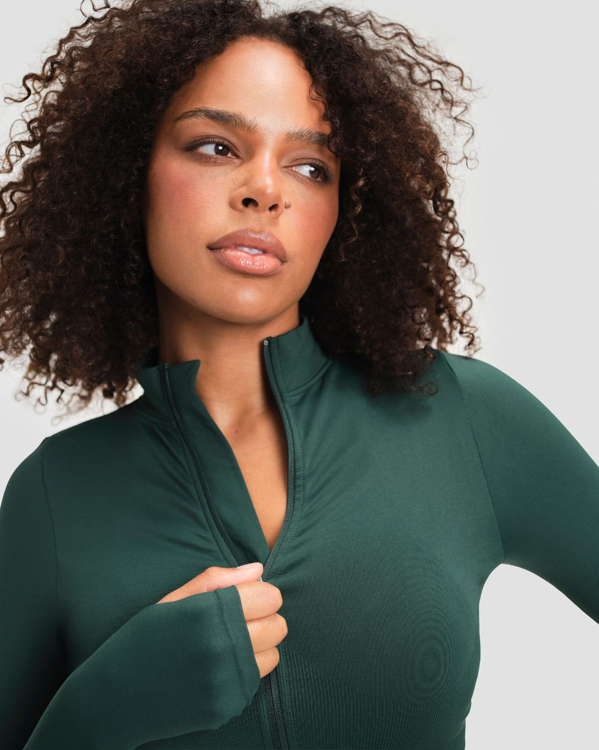 Elevate Compression Long Sleeve Jacket in Pine Green, close-up of stand collar unzipped to the chest with thumbhole cuff