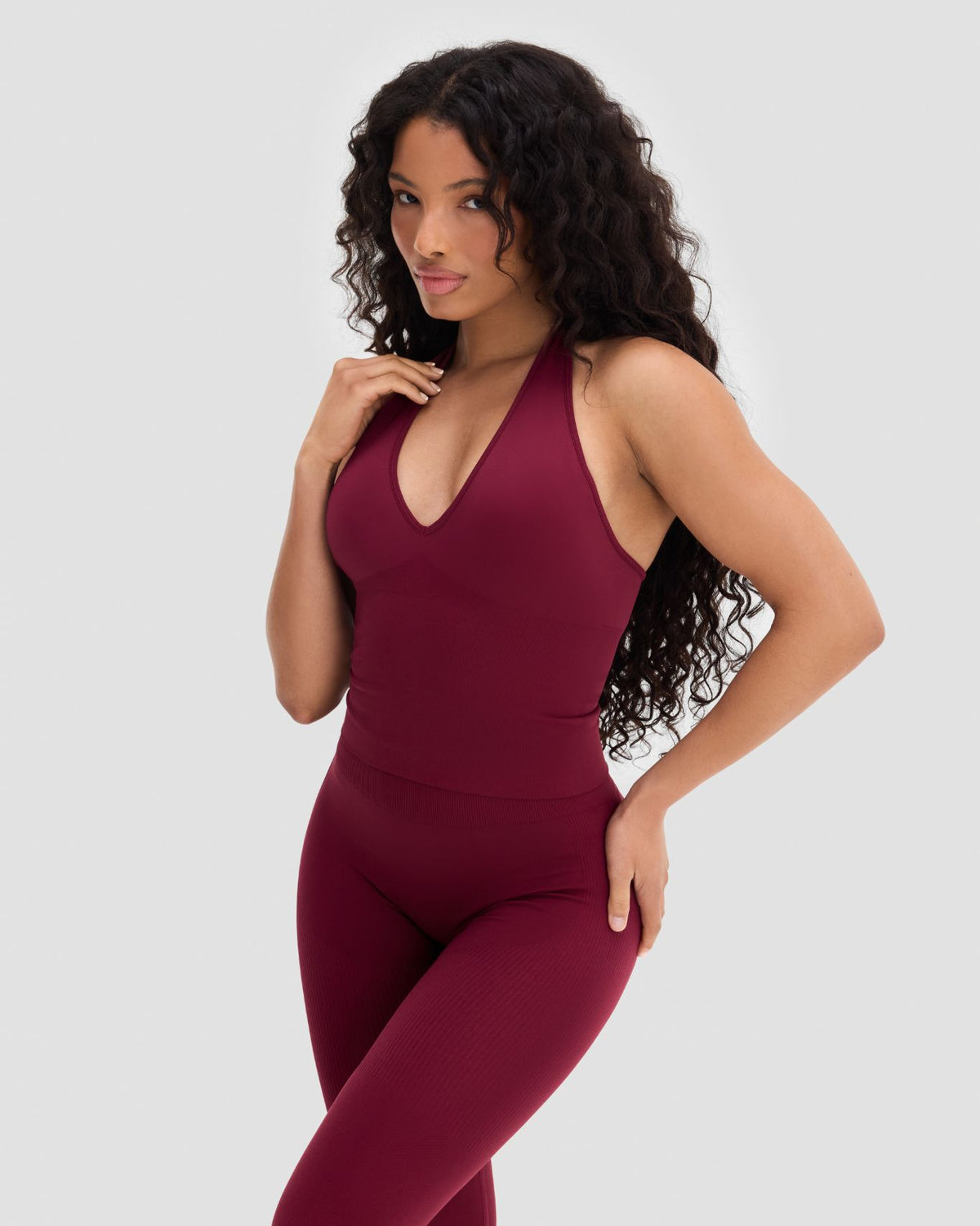 Elevate Sculpting Seamless Halterneck Top in Fine Wine Red, front view with hand on hip, styled with leggings