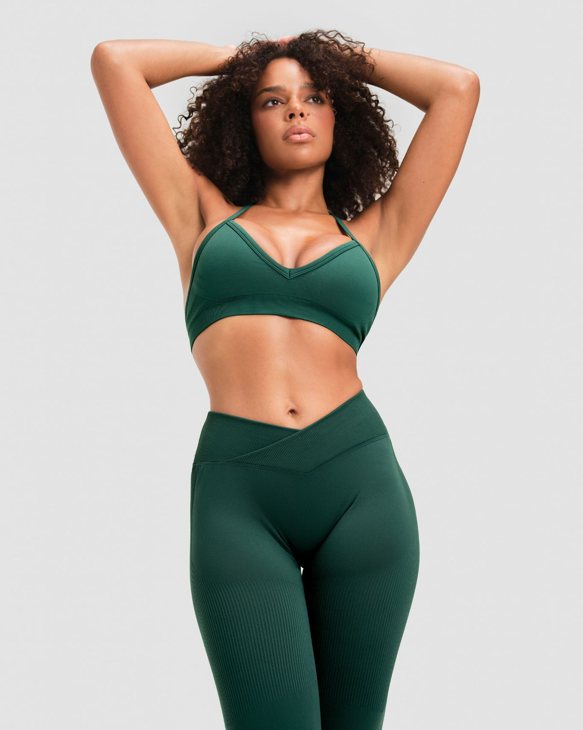 Elevate Sculpting Mid V-Waist Flare Leggings in Pine Green, front view of crossover V-waistband with matching halter bra