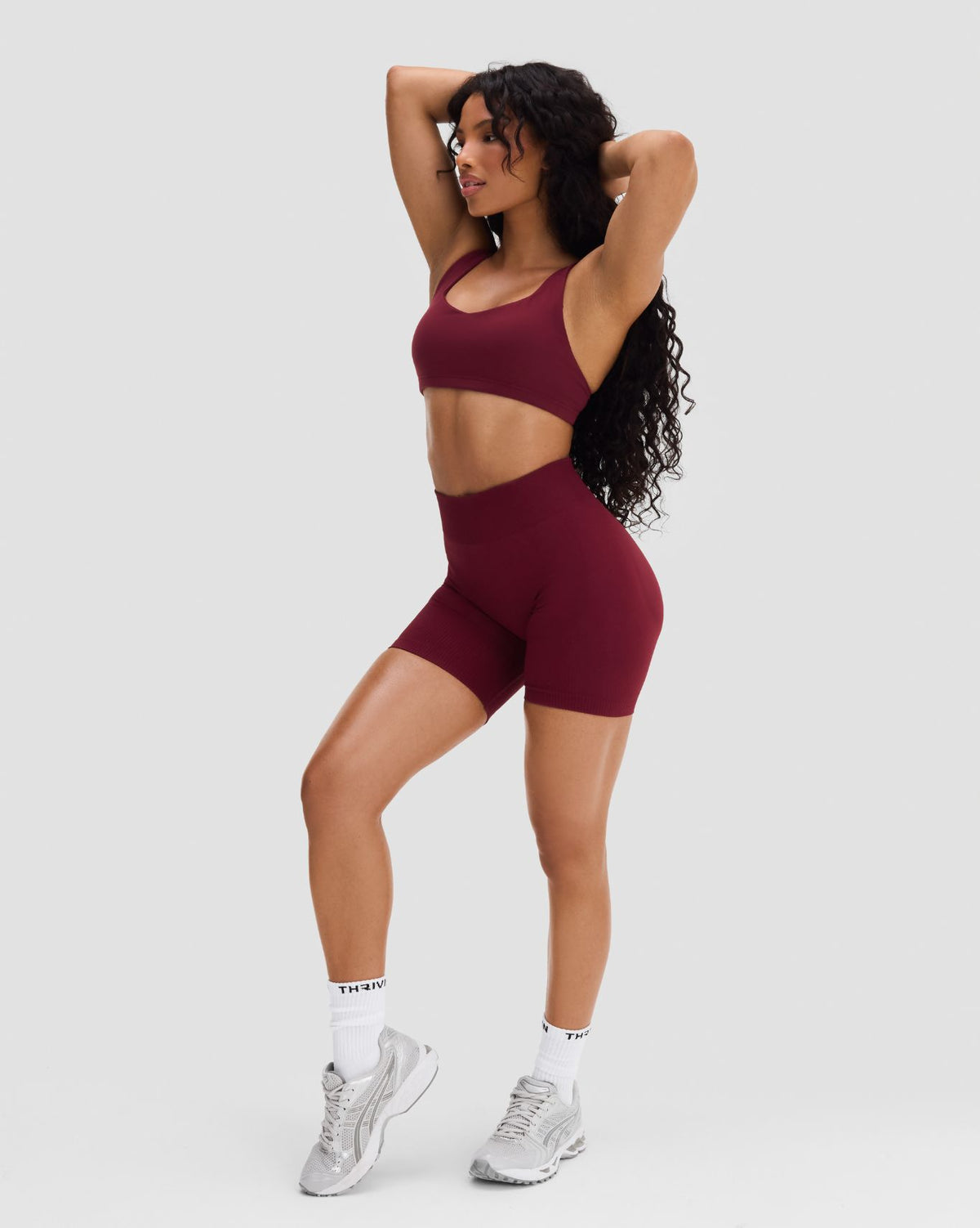 Elevate Sculpting Mid Waist Scrunch Shorts in Fine Wine Red, full-length three-quarter front view showing the mid waist rise