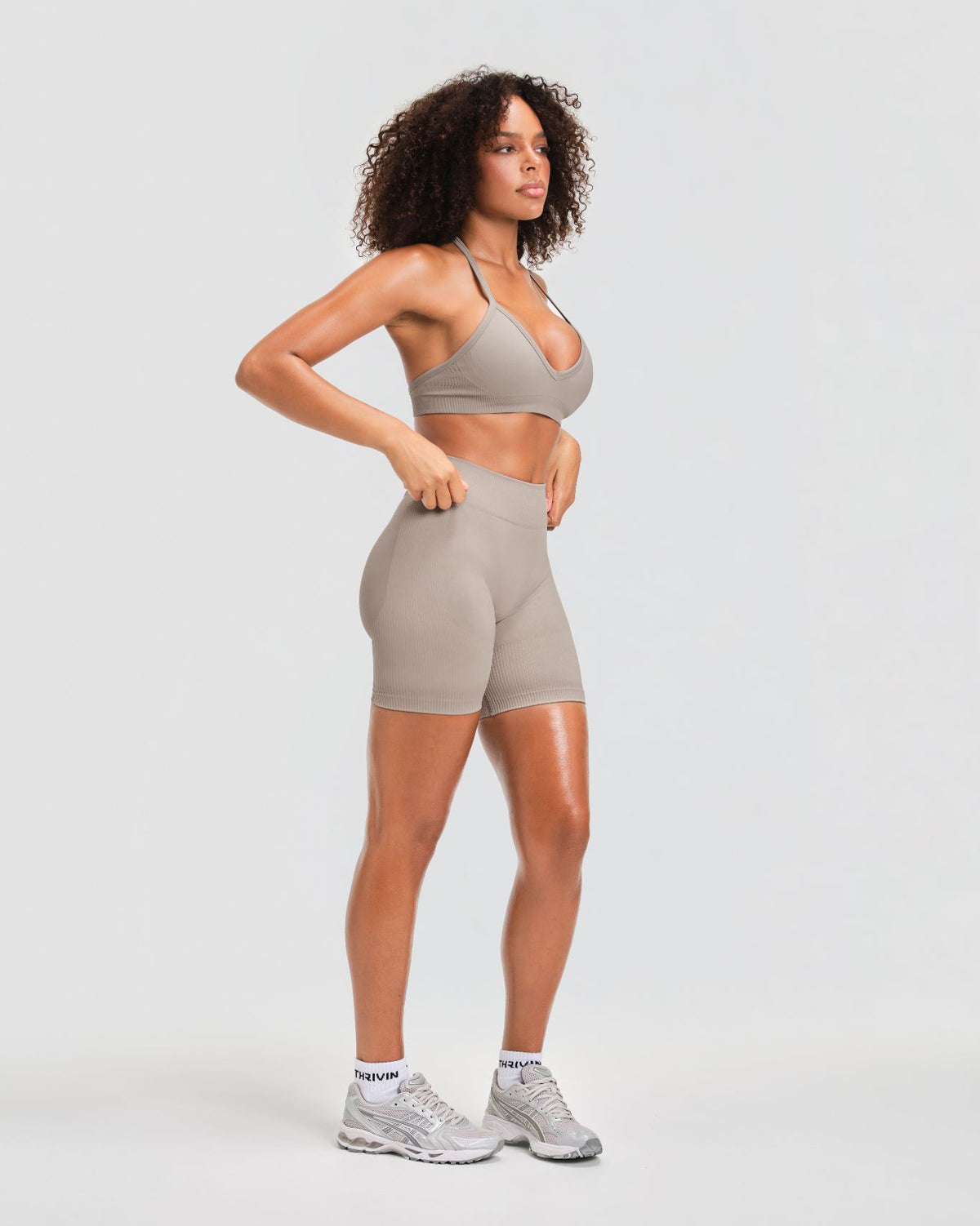 Elevate Sculpting Mid Waist Scrunch Shorts in Latte Grey, three-quarter front view of sculpted fit with halter sports bra