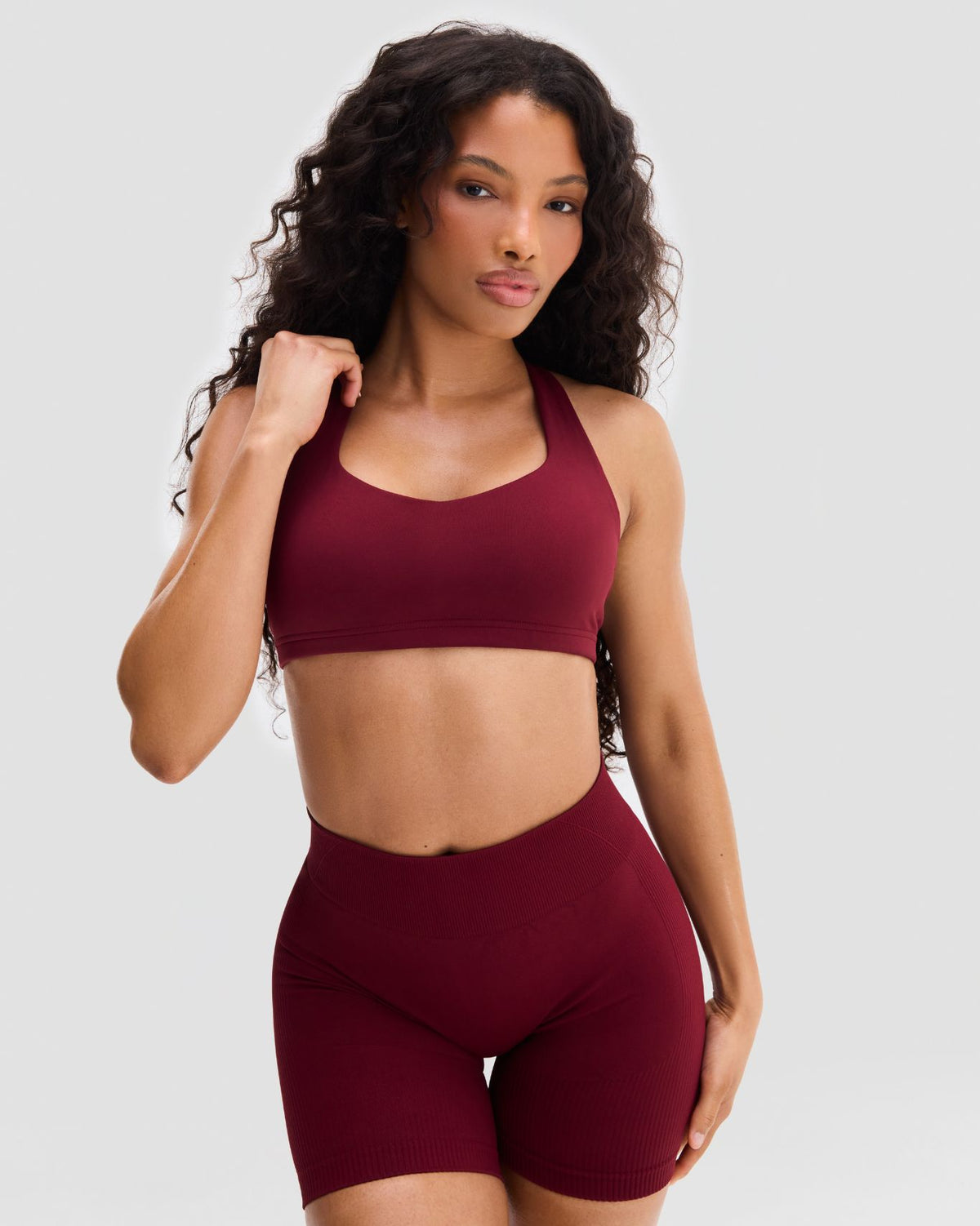 Elevate Sculpting Medium Impact Multiway Bra in Fine Wine Red, front view of bra with matching shorts, standing