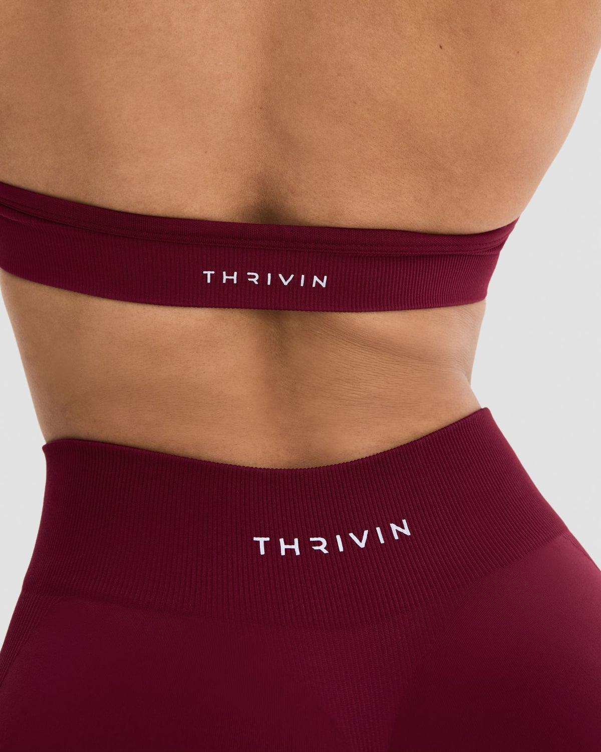 Elevate Sculpting Seamless Adjustable Halter Bra in Fine Wine Red, back close-up of band with THRIVIN logo and waistband