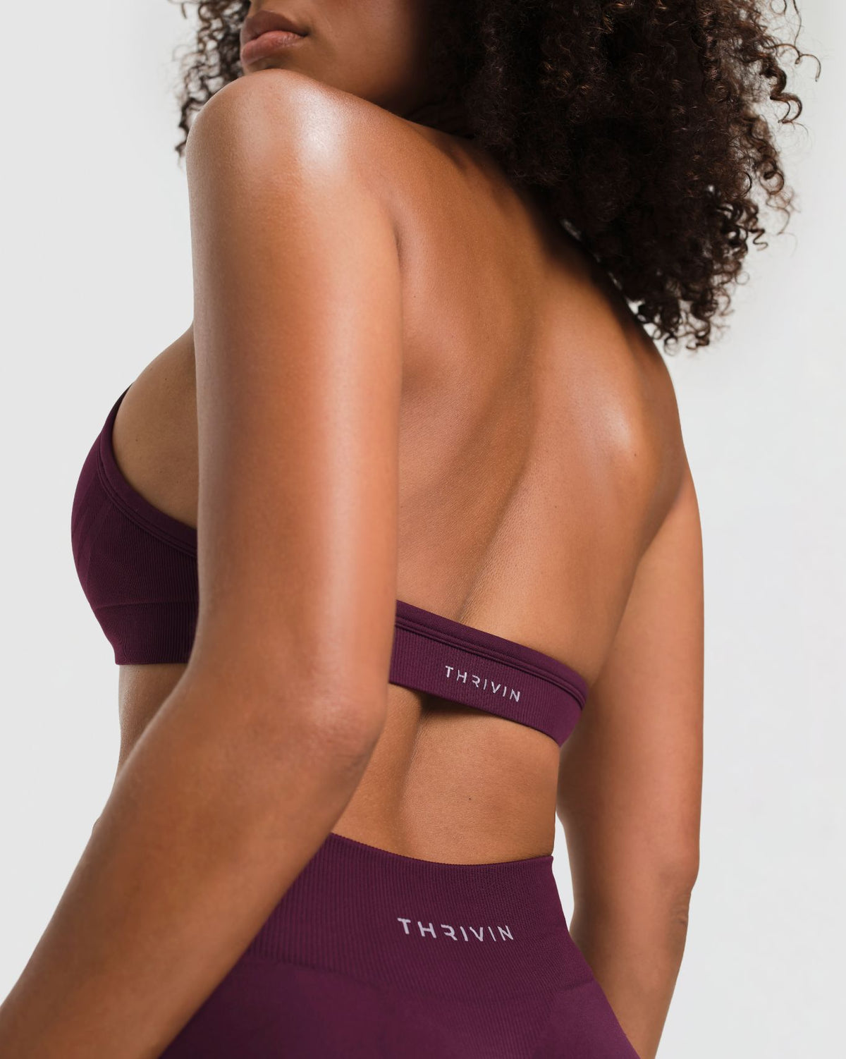 Elevate Sculpting Seamless Adjustable Halter Bra in Winter Plum Red, three-quarter back close-up of THRIVIN logo underband