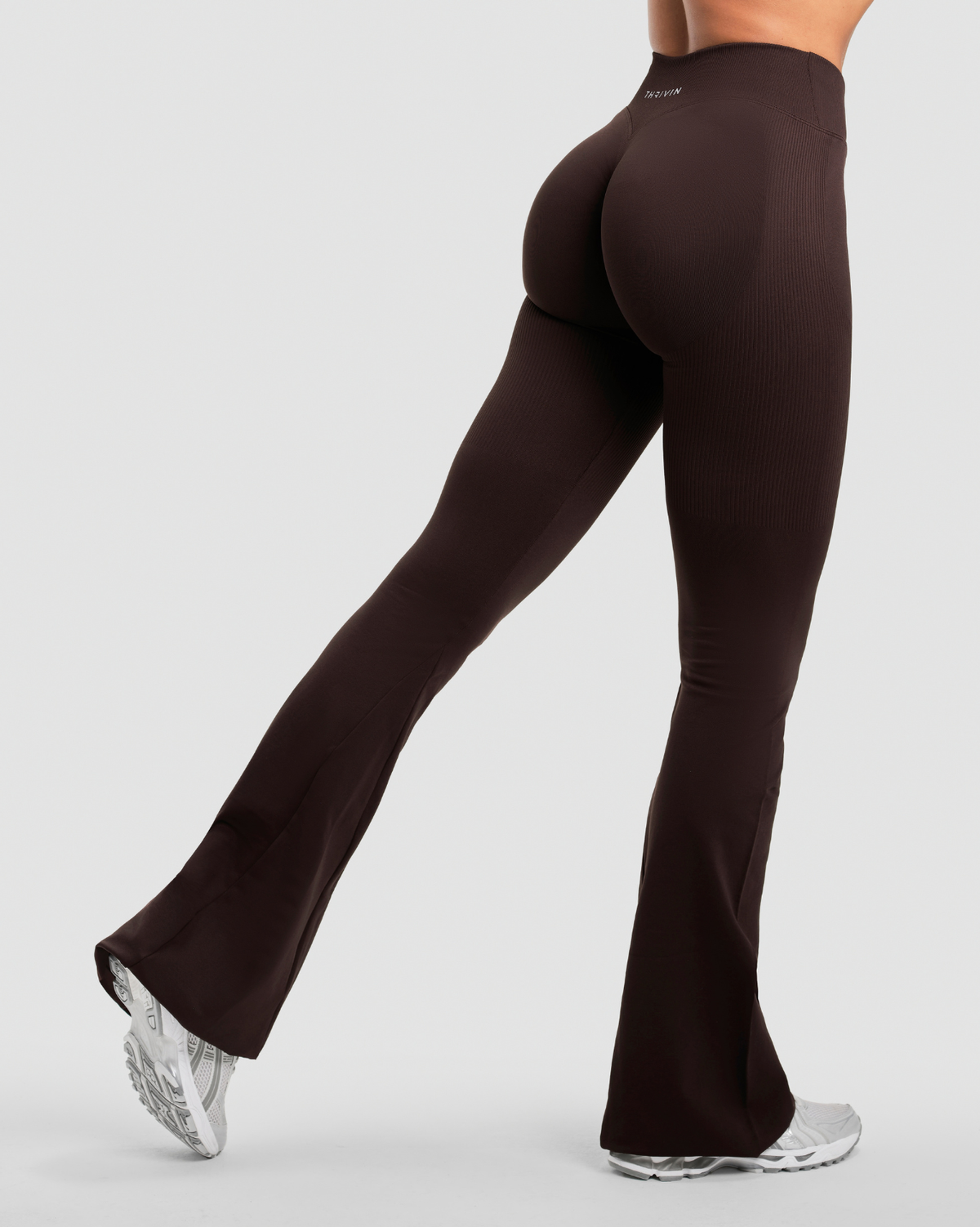 Elevate Sculpting Mid V-Waist Flare Leggings in Coffee Brown, back view mid-stride with scrunch seam and wide flared hem