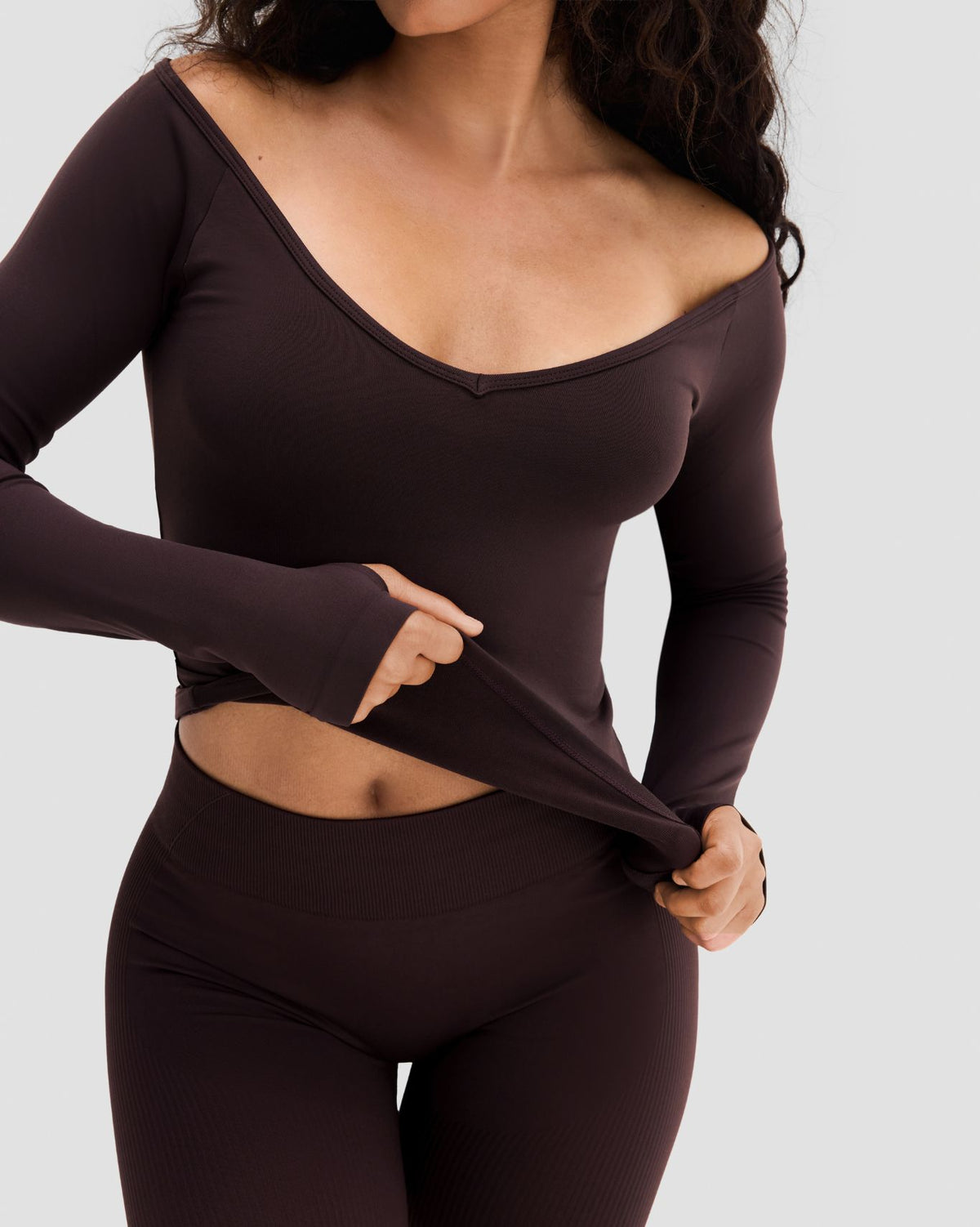 Elevate Sculpting Seamless V-Neck Top in Coffee Brown, front view with wide V-neck, hem lifted