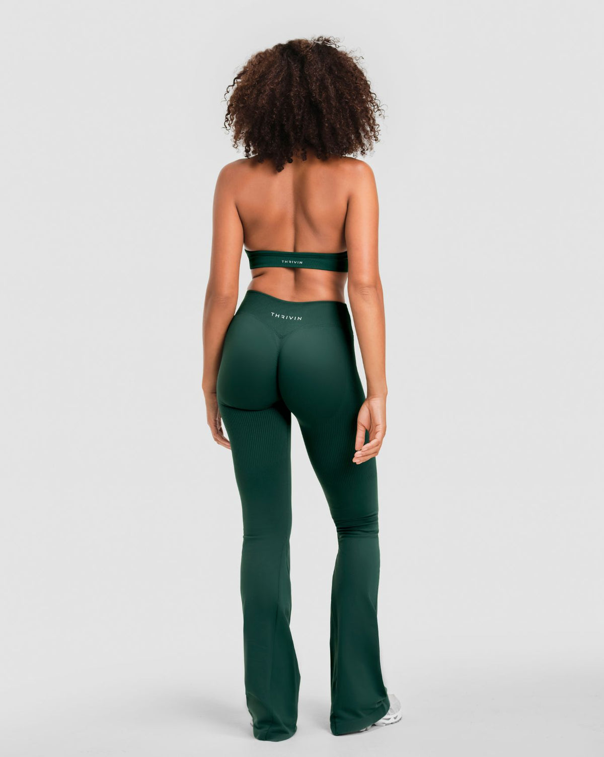 Elevate Sculpting Mid V-Waist Flare Leggings in Pine Green, full-length back view with THRIVIN logo waistband and flared hem