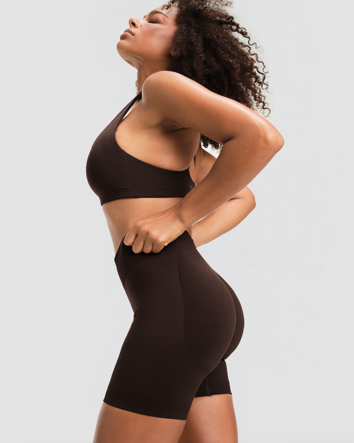 Elevate Sculpting Mid Waist Scrunch Shorts in Coffee Brown, side view of the wide waistband and regular-length leg