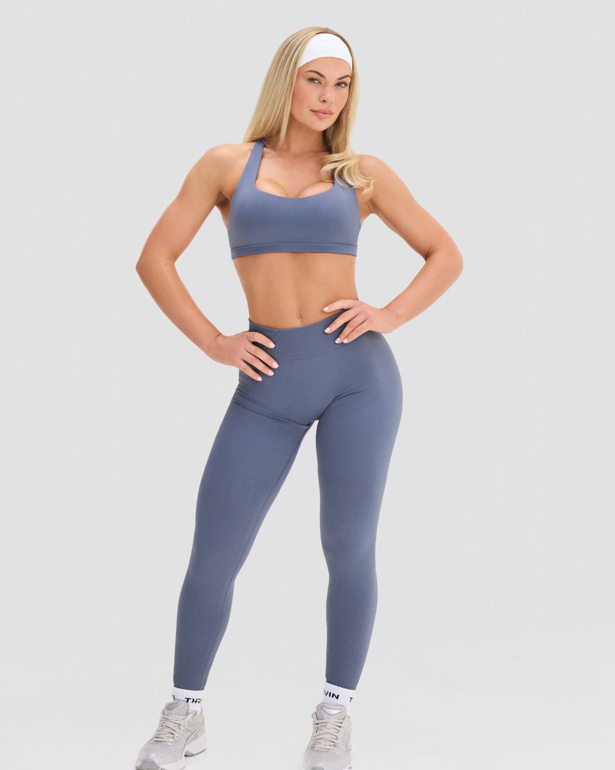Elevate Sculpting Medium Impact Multiway Bra in Steel Blue, front view of scoop neckline and cropped fit above leggings