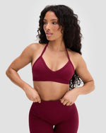 Elevate Sculpting Seamless Adjustable Halter Bra in Fine Wine Red, front view with hands at waist, with matching shorts