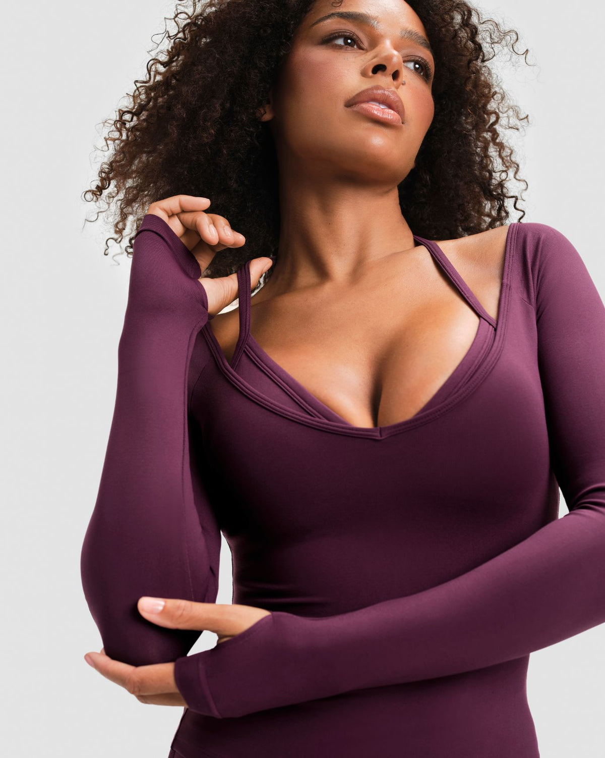 Elevate Sculpting Seamless V-Neck Top in Winter Plum Red, close-up of plunge V-neckline and thumbhole cuffs