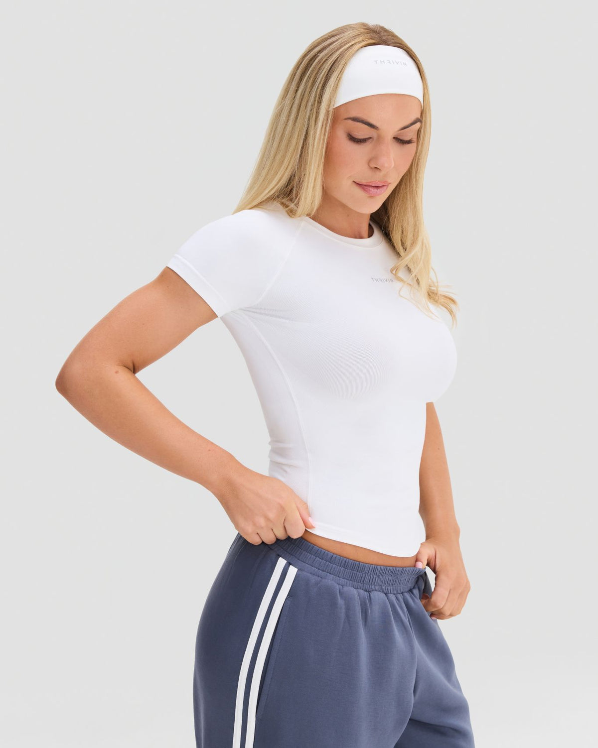 Elevate Compression T-Shirt in White, three-quarter front view showing the close fit, raglan sleeves and side seam