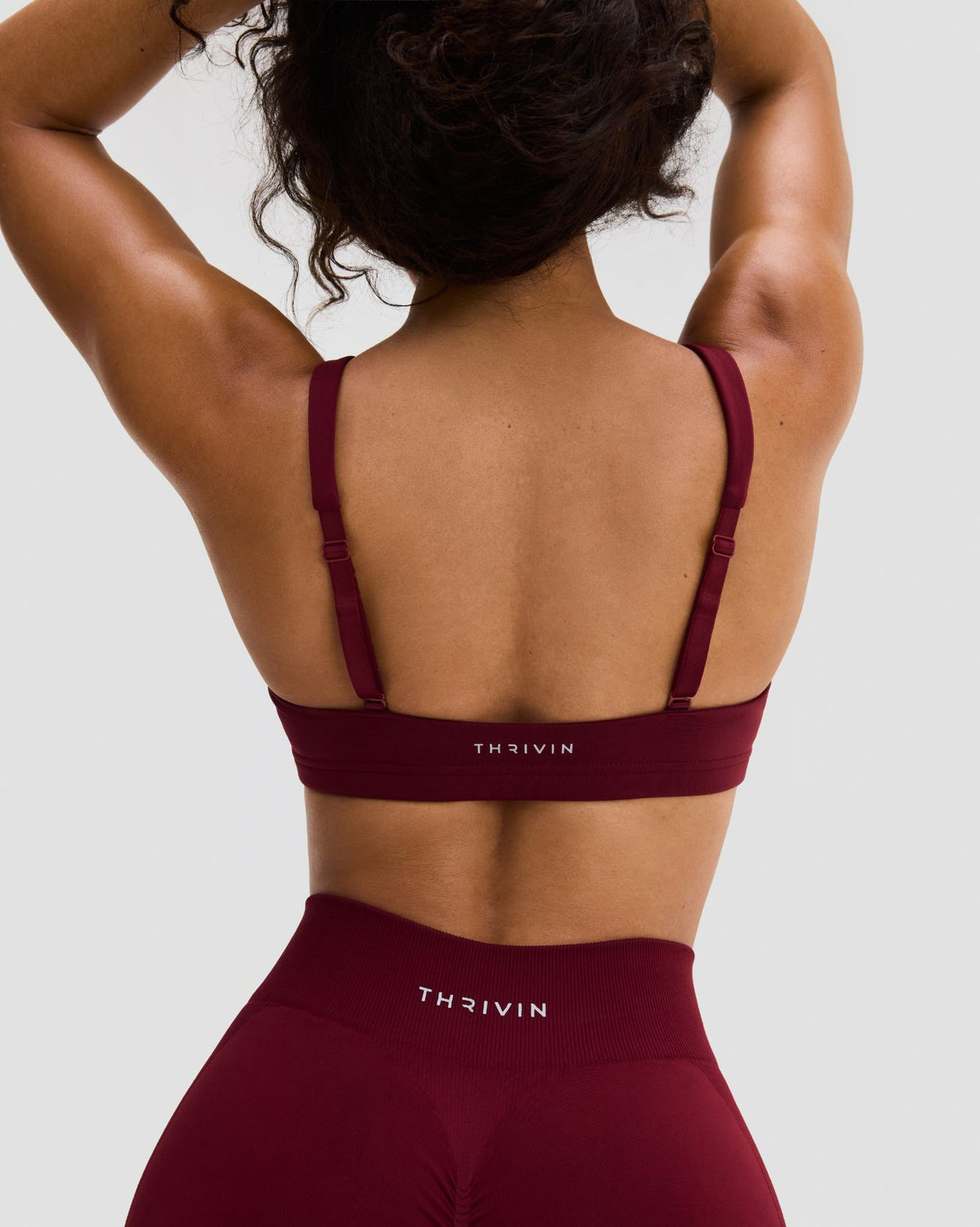 Elevate Sculpting Medium Impact Multiway Bra in Fine Wine Red, back view of adjustable straps and THRIVIN logo band